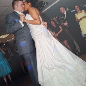 Tania and James share a kiss during their first dance, Tania wearing a strapless Sophia Tolli lace gown with a sweeping train.