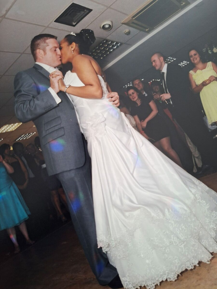 Tania and James share a kiss during their first dance, Tania wearing a strapless Sophia Tolli lace gown with a sweeping train.