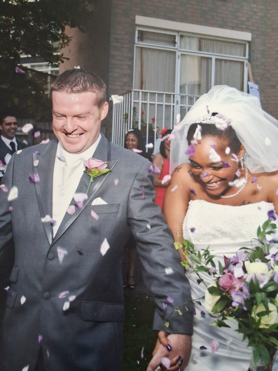 Tania in her Sophia Tolli strapless lace gown laughing with James in a shower of purple and white confetti.