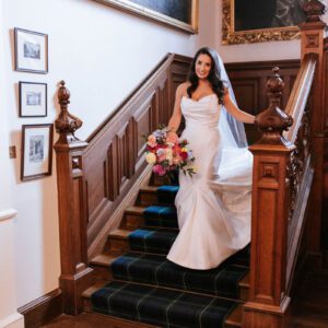 Sophie in her strapless ivory Maggie Sottero mermaid gown descending the grand tartan staircase at Cluny Castle, Aberdeen.